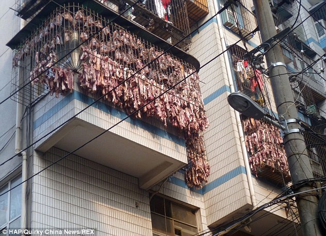 Butcher cures thousands of pork strips off his three story balcony photo