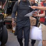 Michael Jordan carries half empty bottle of Tequila and a pillow as he checks out of New York hotel photo